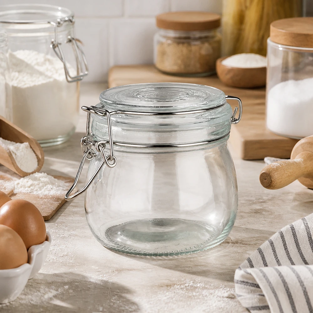500 ml voorraadpot type S met scharnierende top UN. Leeg voorraadpotje van 500 ml met draaidop in een lichtgekleurde keuken naast bakingrediënten en eieren